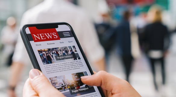 person looking at news on their mobile