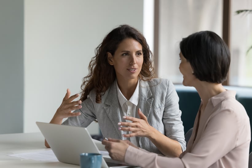 A practice manager going through the week ahead with a colleague at a desk