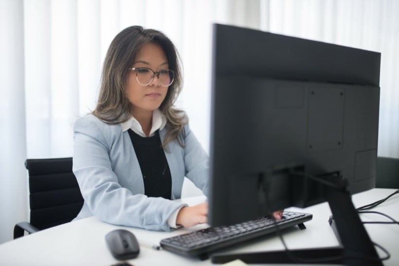 A practice owner at her desk, working through the day on her monitor