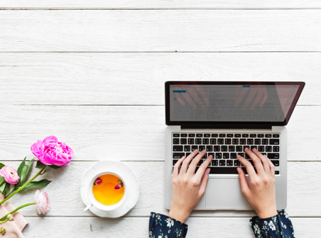 Person on laptop drinking tea