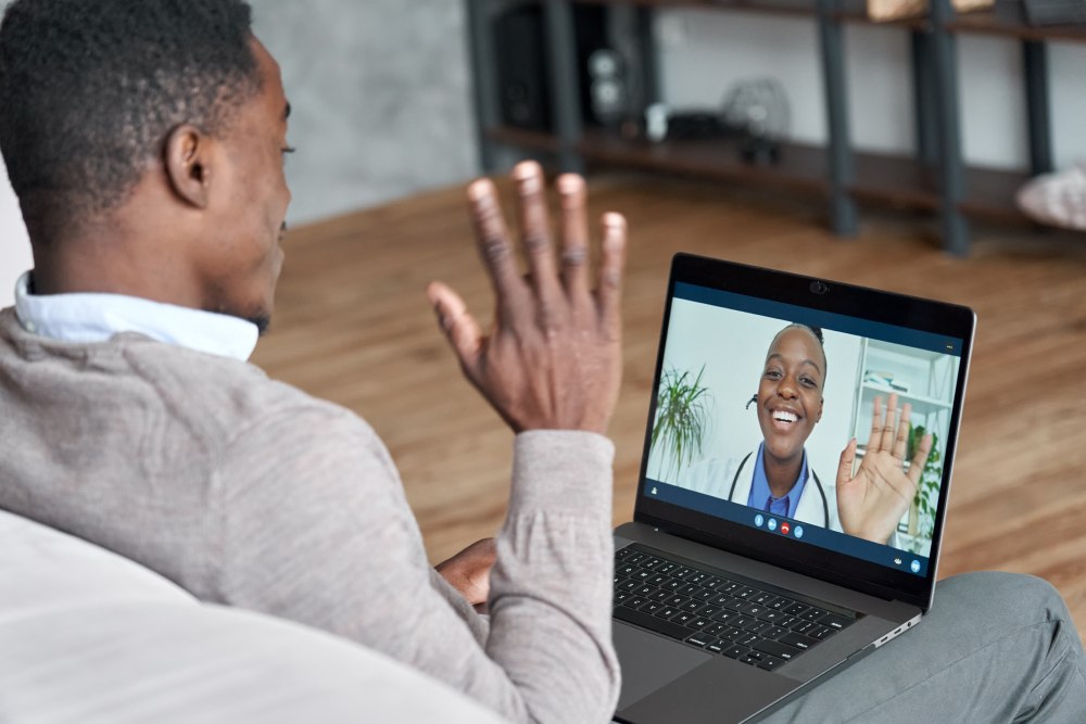 Man having a telehealth appointment from his laptop with a health care professional